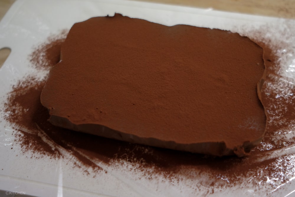 在生巧克力的兩面上撒上巧克力粉